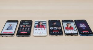 複数のスマートフォンが並んでいる写真。それぞれの画面にはマッチングアプリのインターフェースが表示されている様子