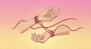 手首が赤い紐でつながれている