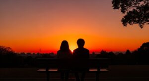 夕焼けのベンチのカップル